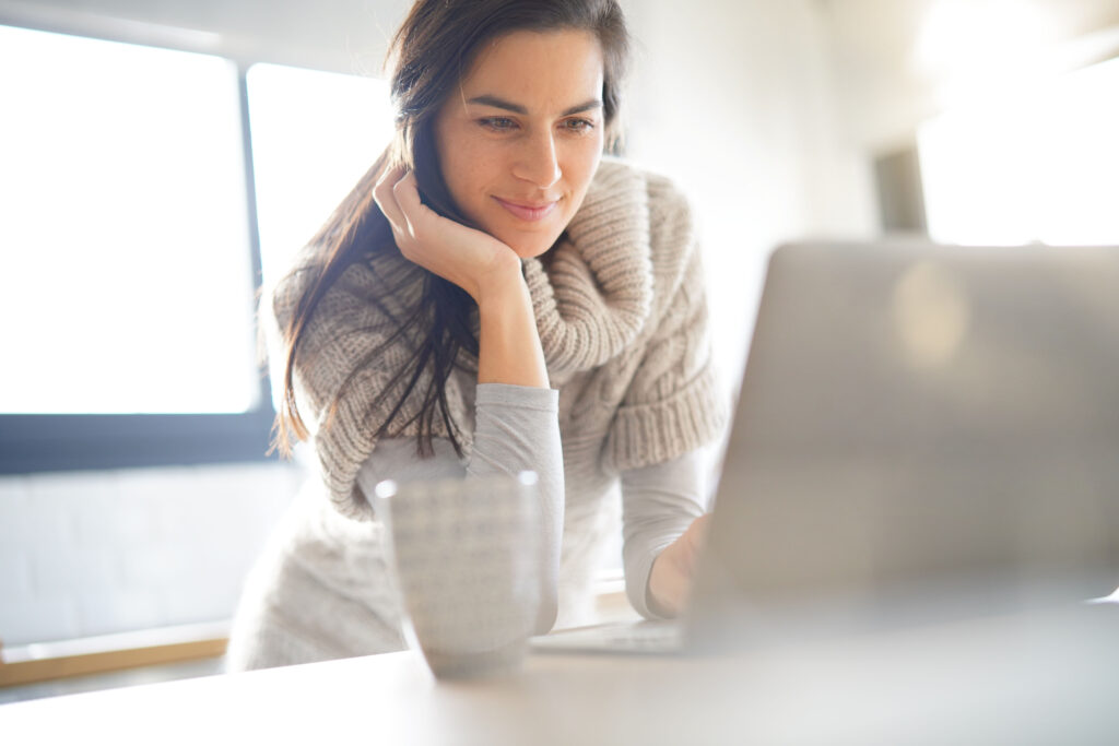 Brunette woman on a laptop educating herself about her breast cancer risk using MagView's breast cancer risk tools